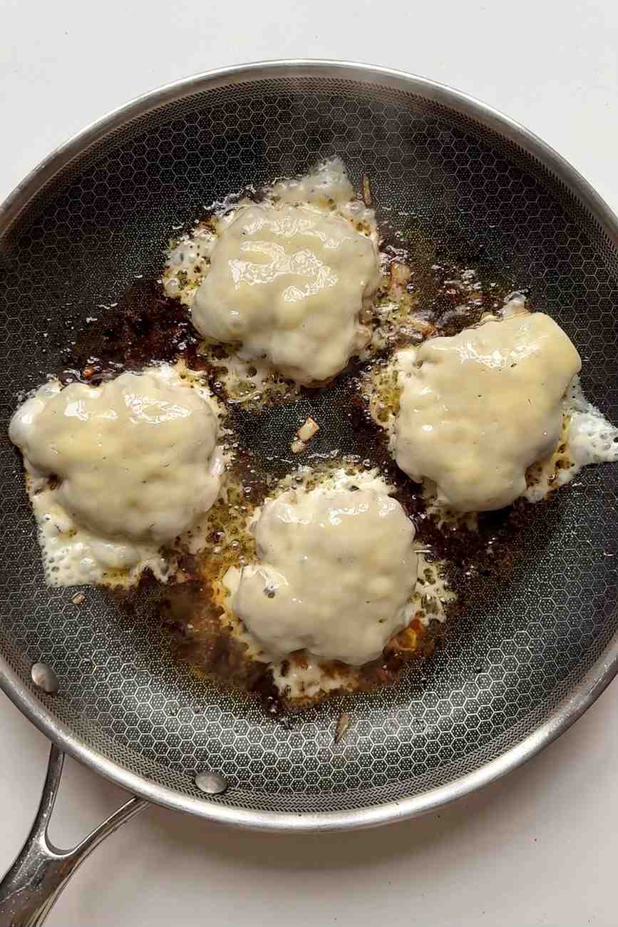 frying burgers in a pan.