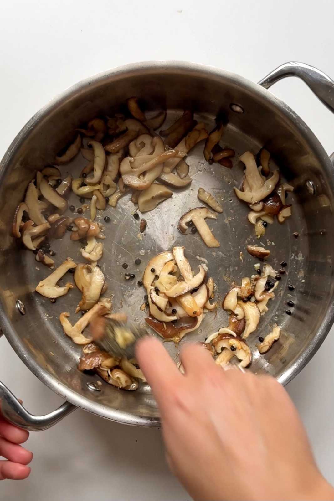 frying mushrooms in a pan.