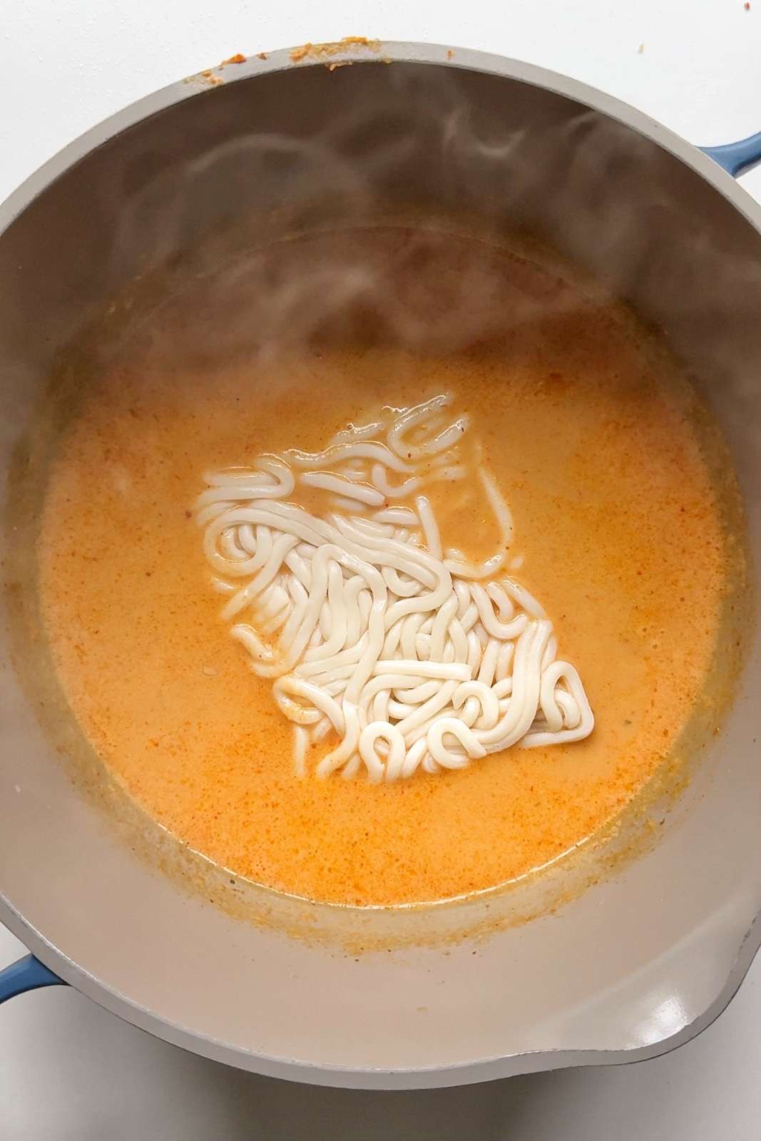 Adding noodles to katsu broth.