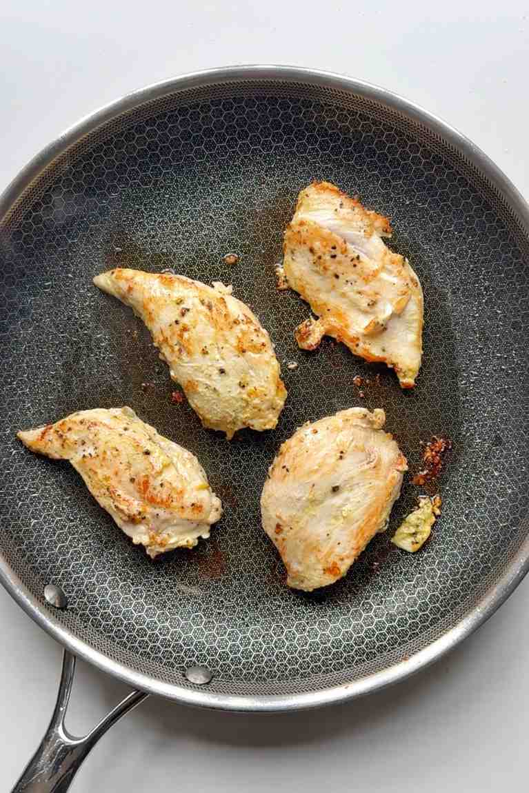 Frying dijon mustard chicken in a pan.