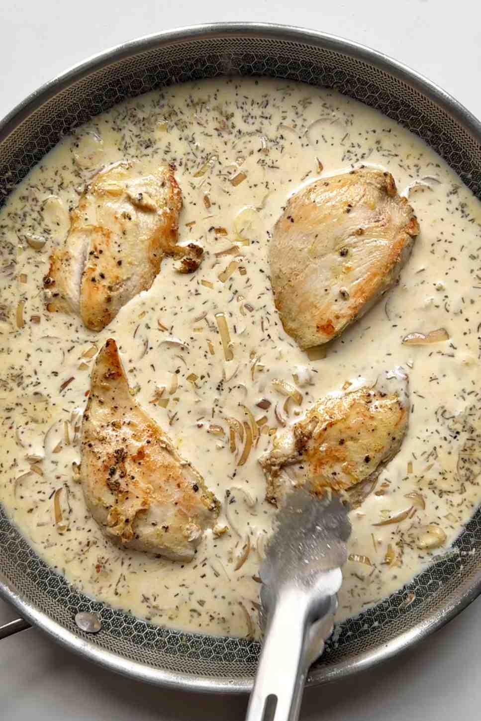 Adding chicken back to dijon mustard frying pan.