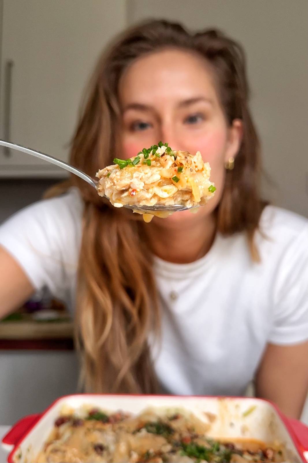Emily holding up a spoon of the viral dumpling lasagna.