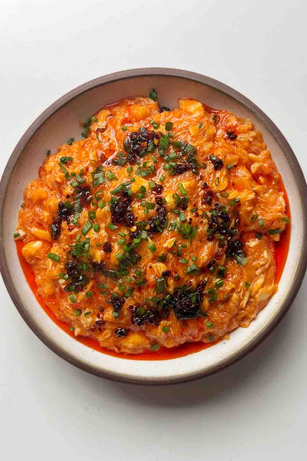 Chilli crab noodles in white bowl.