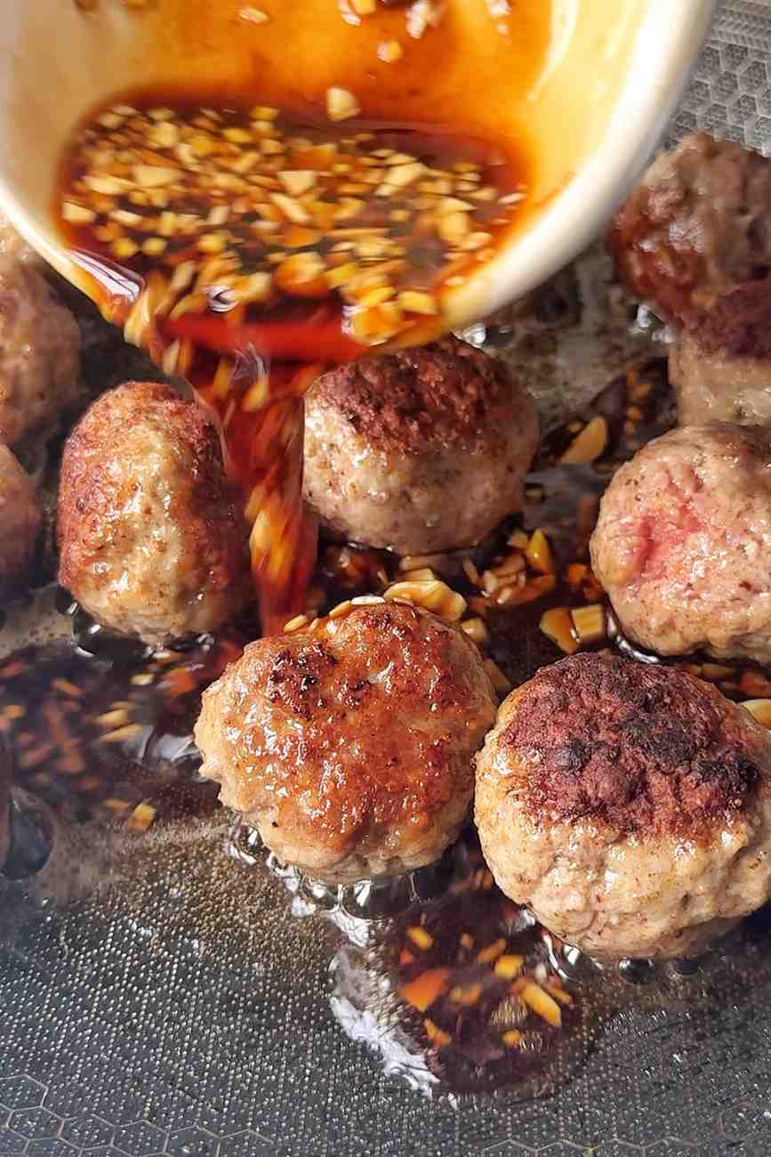 Pouring the teriyaki sauce into the pan.