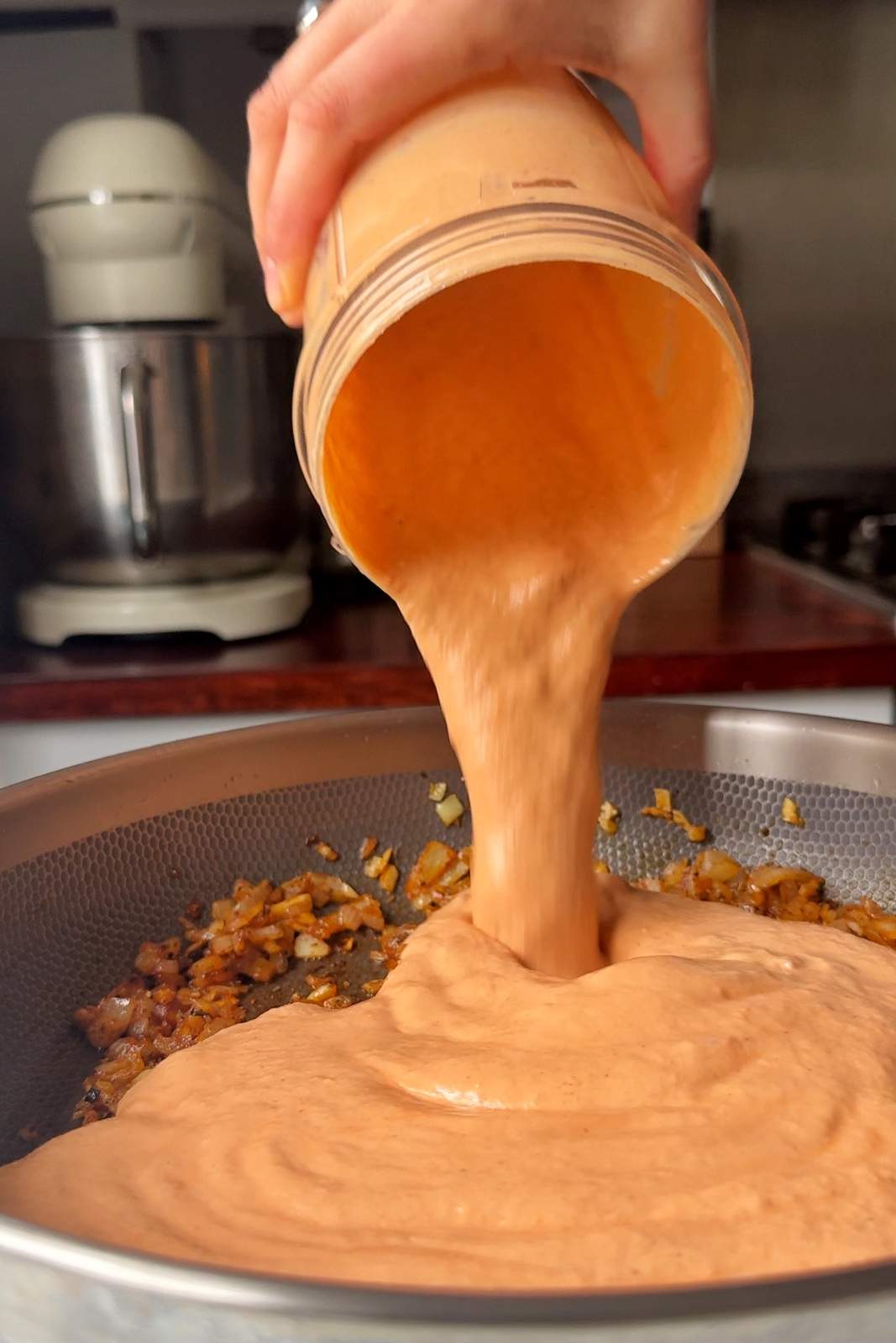 Adding spicy Boursin sauce into pan.