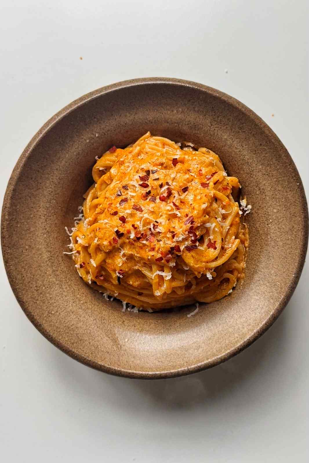 bowl of spicy Boursin pasta on white background.
